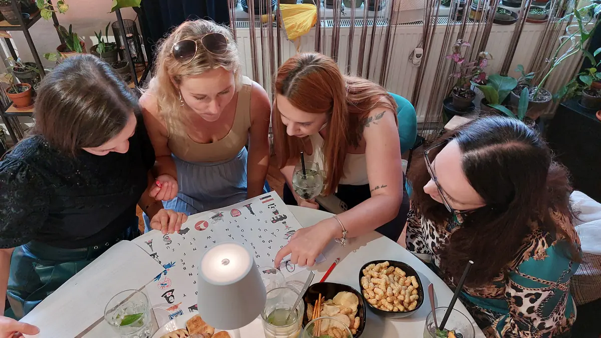 Kolegovia spolupracujú pri riešení šifry počas firemnej párty hry.