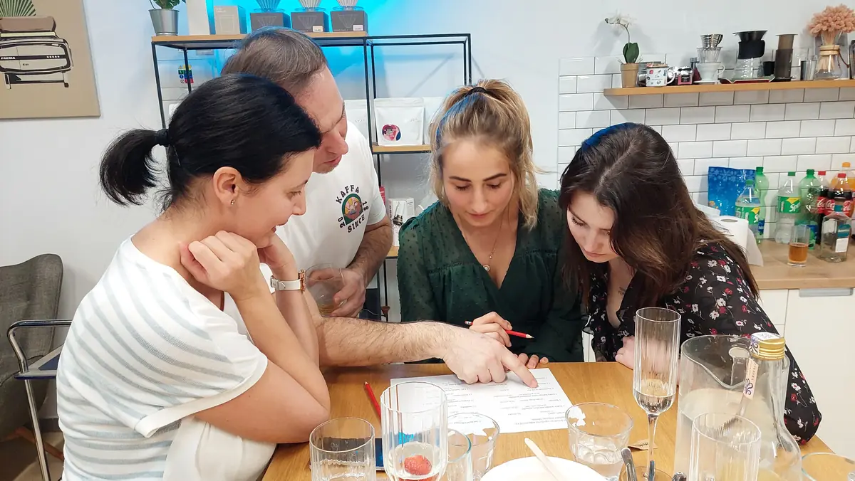 Tím rieši kvíz v rámci vianočnej firemnej párty hry pri stole s občerstvením.