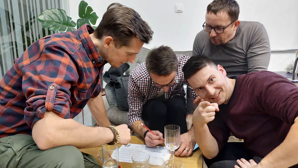 Tím kolegov rieši úlohu vtipnej firemnej párty hry počas vianočneho večierku