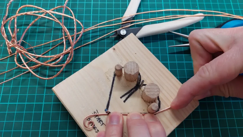 Účastník teambuildingu vytvára drôtený výrobok počas drotárskeho workshopu