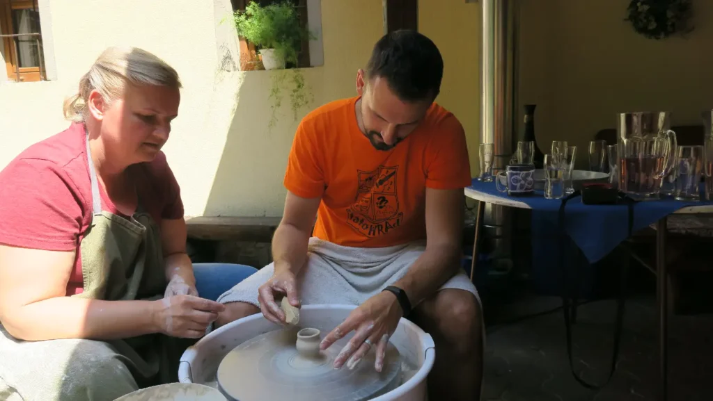 Účastníci teambuildingu tvoria keramiku na hrnčiarskom kruhu počas workshopu
