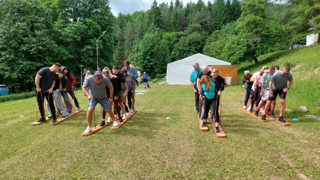 Tímy sa snažia koordinovať pohyb na obrích lyžiach – zábavná teambuildingová aktivita zameraná na spoluprácu a koordináciu