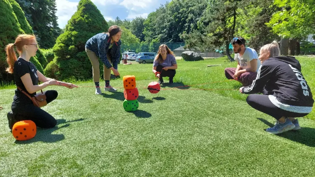 Tím stavia vežu z penových kociek pomocou slučky bez použitia rúk – teambuildingová aktivita zameraná na spoluprácu