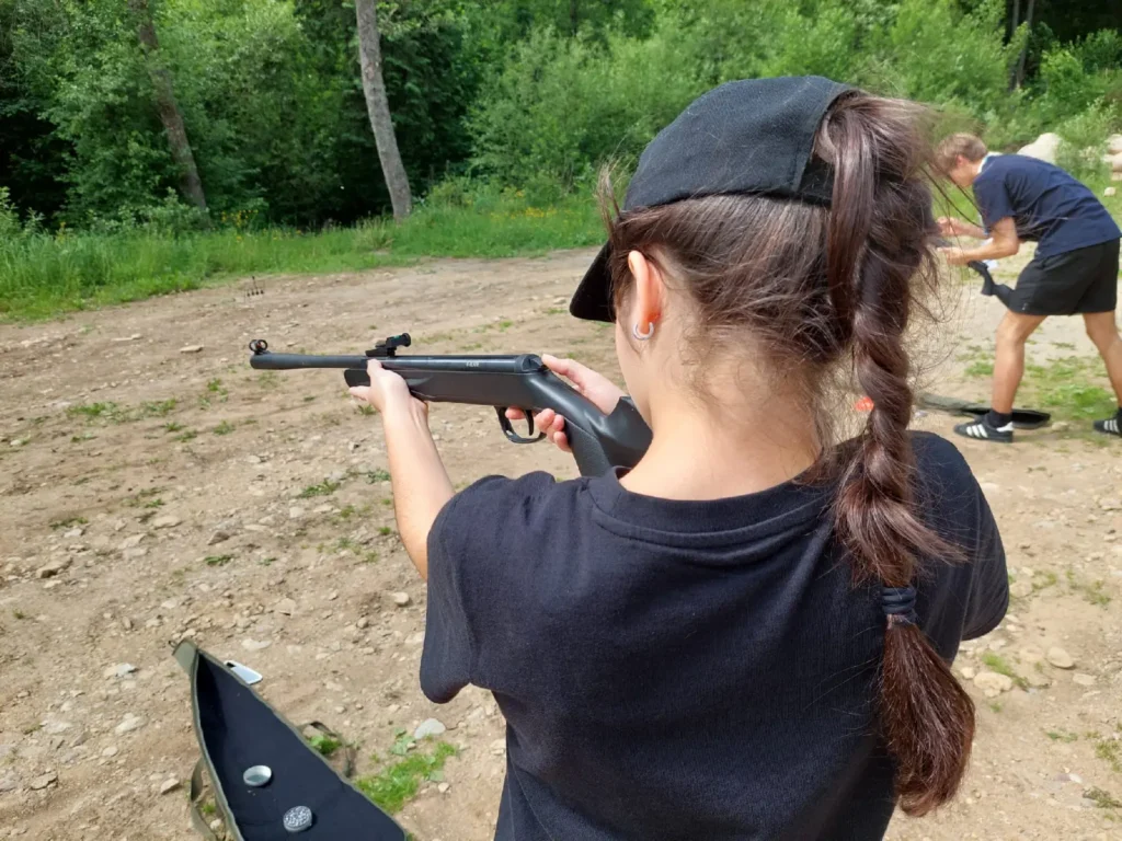 Účastníčka teambuildingu mieri zo vzduchovky na terč – aktivita zameraná na presnosť a sústredenie