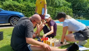 Tím rieši logickú úlohu počas outdoor šifrovacej hry na teambuildingu