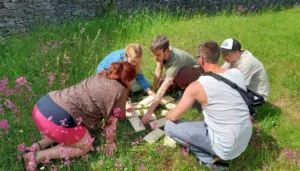 Tím rieši logickú úlohu v prírode počas teambuildingu vo forme outdoor šifrovacej hry