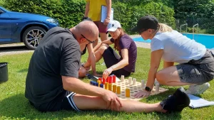 firemná šifrovacia hra – tím rieši šifru s farebnými valčekmi počas teambuildingu